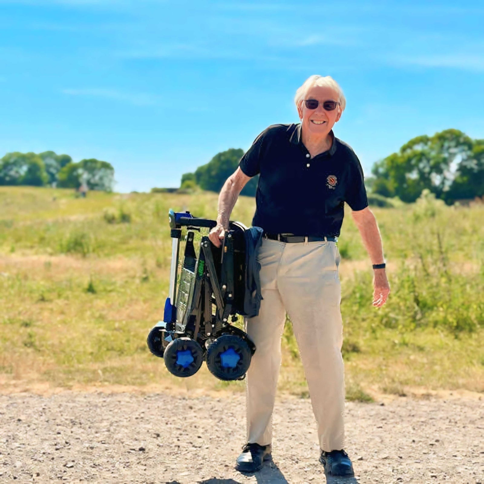Folded mobility scooter lifted up by elderly man