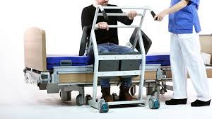 Patient being assisted to use Direct Healthcare Group Mover Aqua Transfer Platform