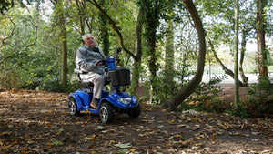 elderly man riding a Blue Scooterpac Ignite 8mph Electric Mobility Scooter 40 Mile Range