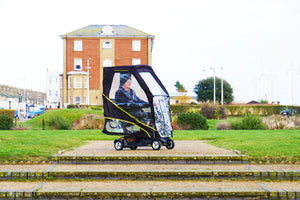 elderly man using the Scooterpac Universal Foldaway mobility scooter Canopy. automated Rain protection