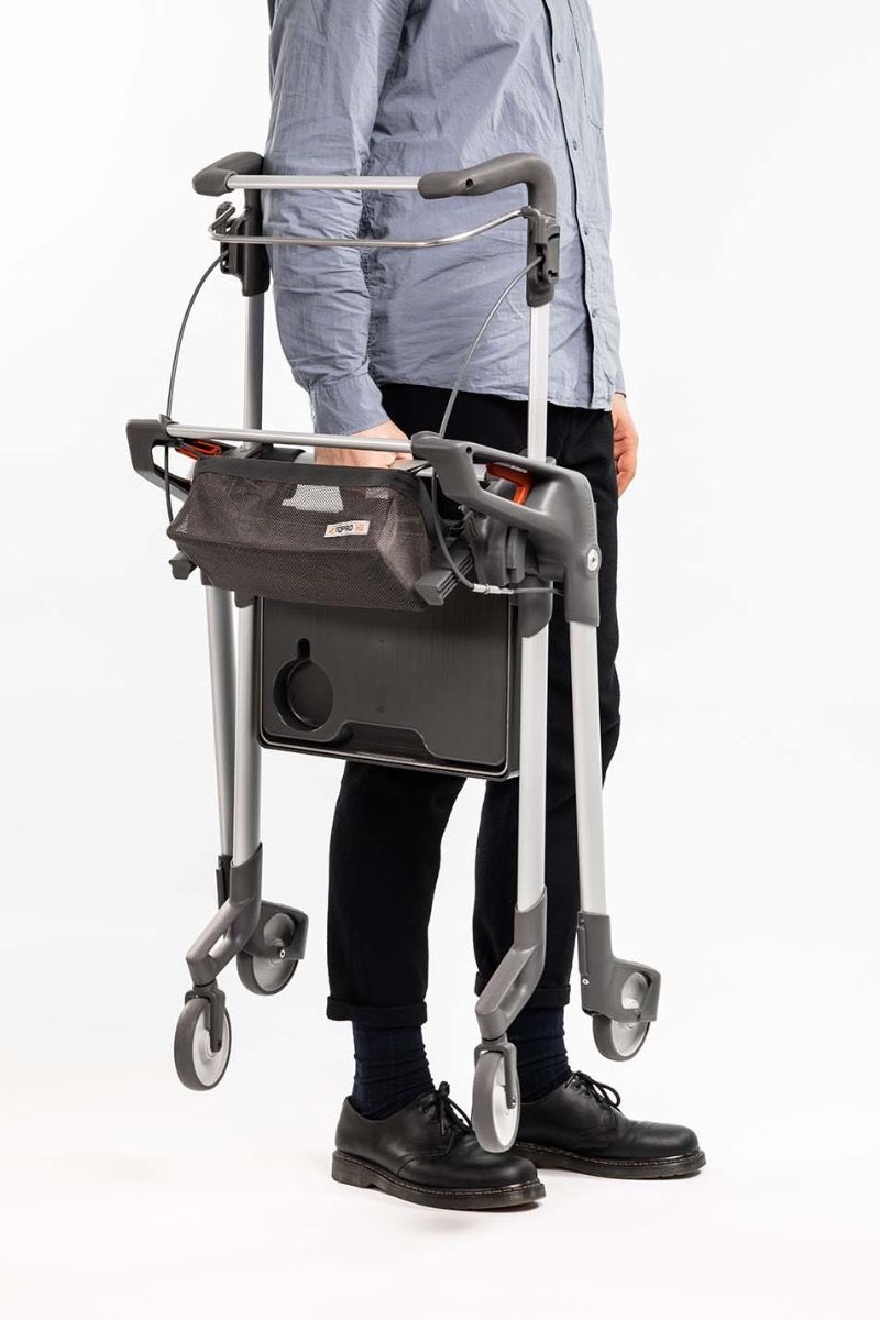 man carring a ToPro Hestia lightweight Rollator folded 