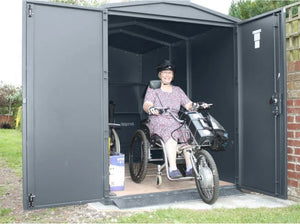 Woman driving out of the Asgard Mobility Scooter Storage Shed. Secure Scooter Garage Protection Against Theft and Weather