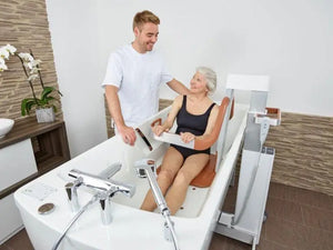 Astor Bannerman Eve Multi Functional Shower and Bath Lift in use by a female patient in a bath