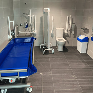 Astor Bannerman Electric Height Adjustable Shower Trolley 200kg Capacity in a disabled bathroom view 1