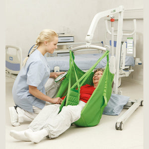 Hillrom M220 M230 Mobile Hoist in use to lift patient off the floor