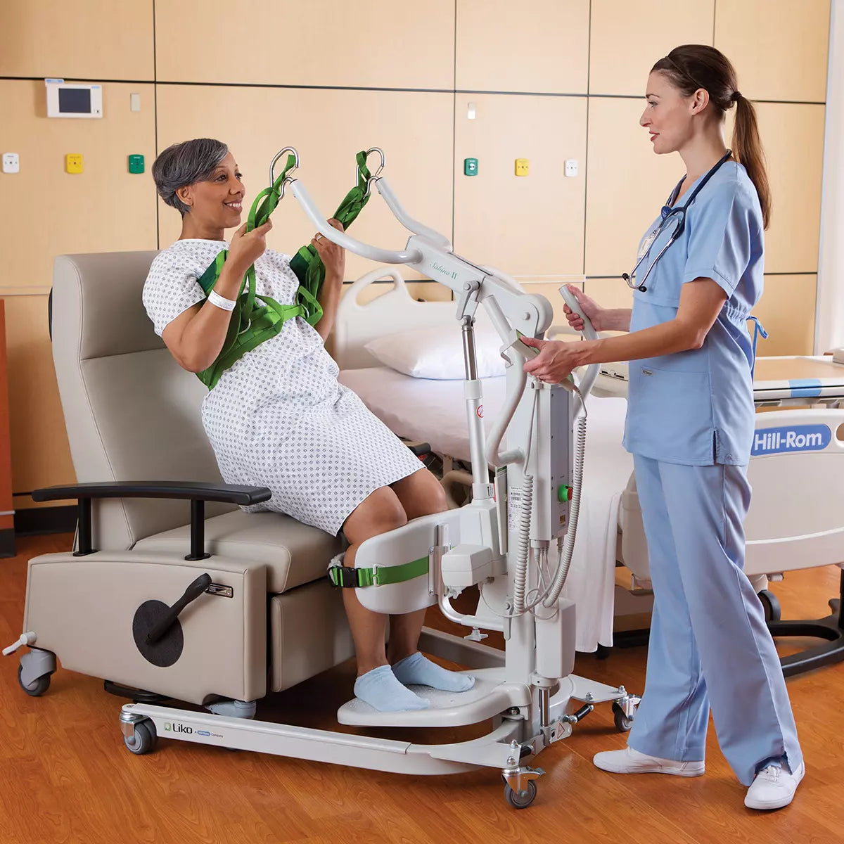 Hillrom Sabina II EE Mobile Lift in use to lift patient to a chair