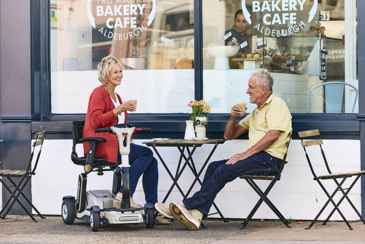 Motion Healthcare Connex Automatic Folding Mobility Scooter in colour sand in use