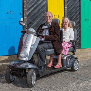 Elderly couple riding Scooterpac Tandem 2 Seat Mobility Scooter. Two-Person Mobility Solution
