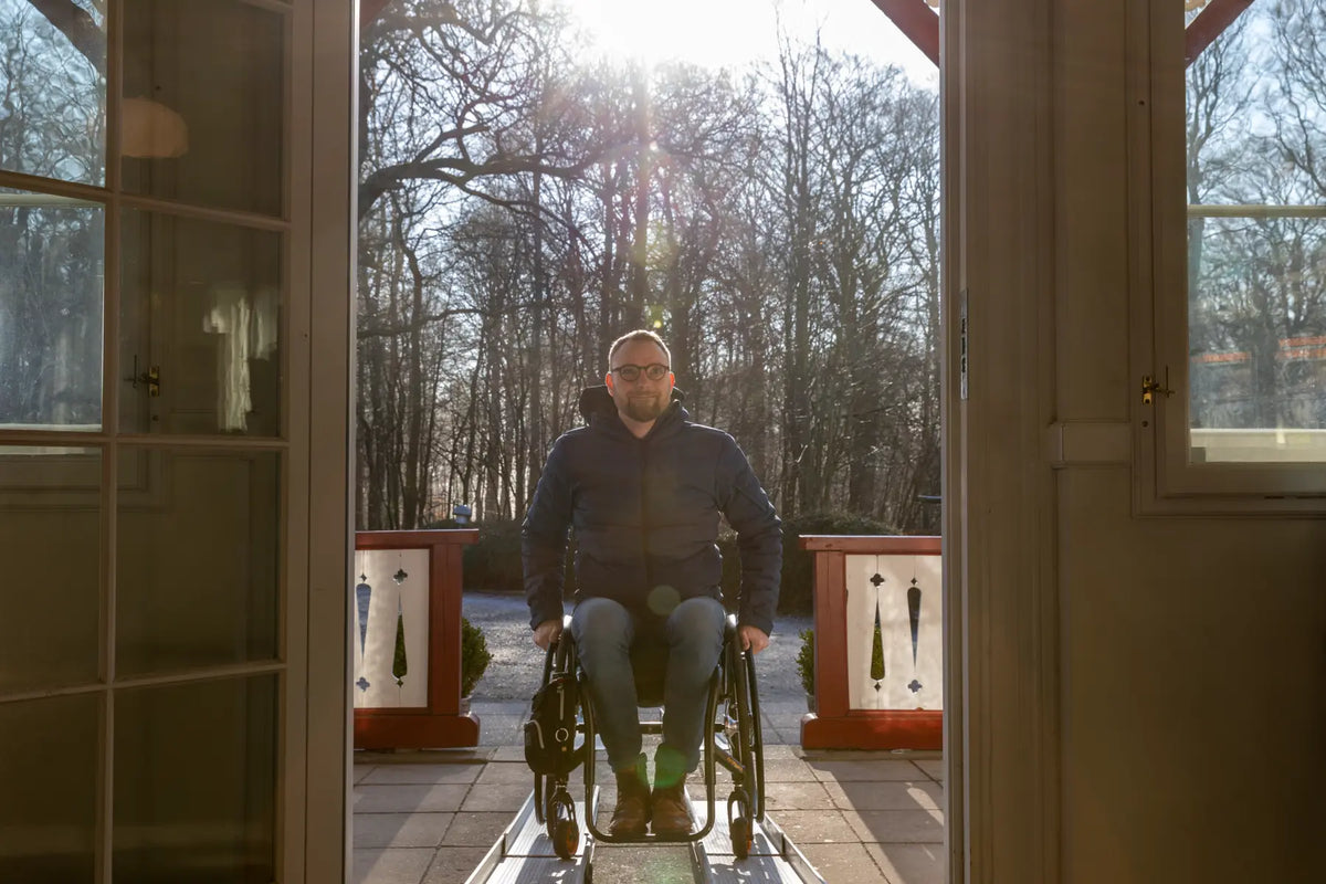 Stepless Guldman Telescopic Ramp in use by wheelchair user going indoors