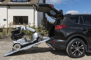 Enable Access Aerolight Lifestyle Multi-Folding Wheelchair Ramp unfolded on stairs on  van bumper  with mobility scooter going into the van 