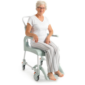 Etac | Enhance Comfort and Accessibility with the Clean Shower Commode Chair Designed for Easy Maneuverability and Optimal Hygiene woman using 