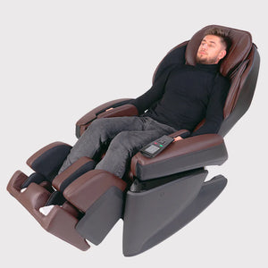 Man using the brown Fujiiryoki JP-1100 Zero Gravity Electric Massage Chair