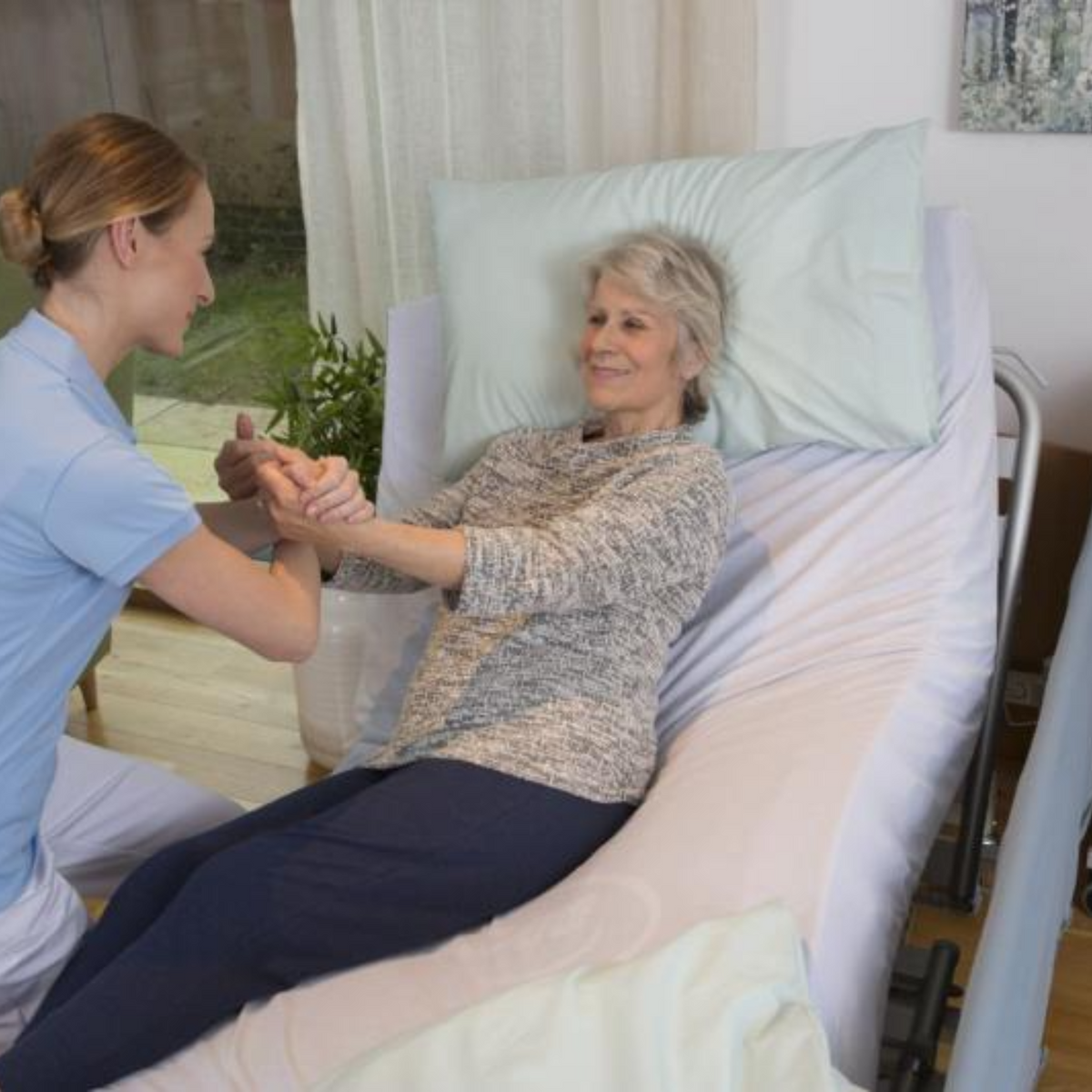 Invacare | Soft Tilt Automated and Manual Patient Repositioning. Nurse using with woman tilted on side