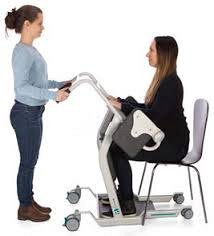 Side view of woman being assisted to use Direct Healthcare Group Mover Aqua Transfer Platform from chair