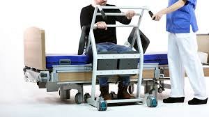 Patient being assisted to use Direct Healthcare Group Mover Aqua Transfer Platform 