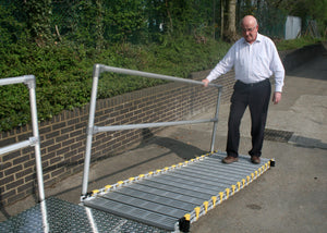 man using the Roll-a-ramp portable and foldable disabled wheelchair ramp with handrail