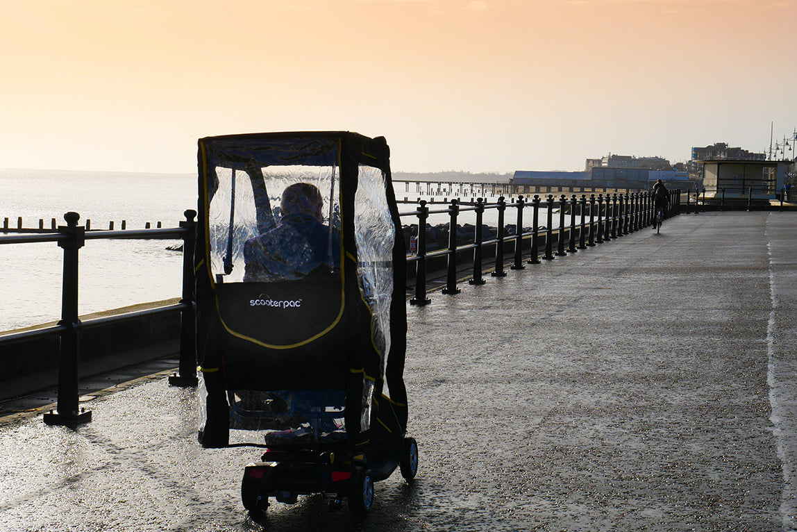 Elderly person using the Scooterpac Universal Foldaway mobility scooter Canopy. automated Rain protection