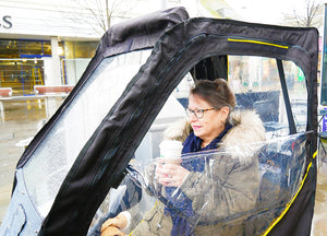 woman inside a Scooterpac Universal Foldaway mobility scooter Canopy. automated Rain protection with window flap